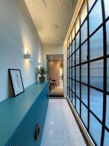 un couloir avec un comptoir bleu et de grandes fenêtres dans l'établissement NoOne Tropea Guesthouse, à Tropea