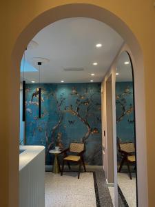 特羅佩阿的住宿－NoOne Tropea Guesthouse，带有蓝墙的走廊,带有树壁画