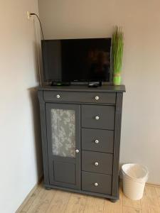 a black dresser with a television on top of it at Lüttes Huus in Emden