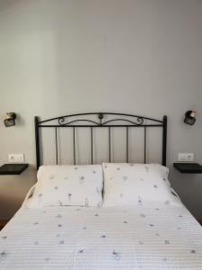 a bed with a black frame and a white bedspread at La casona El Espín in Serandinas