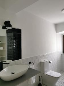 a white bathroom with a sink and a toilet at La casona El Espín in Serandinas +28 photos