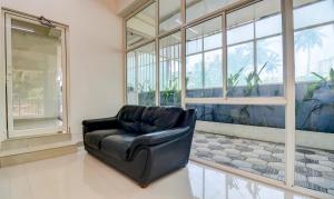 a black leather chair in a room with windows at Itsy By Treebo - Ushodaya Royal Residency in Trivandrum