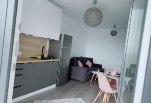 a kitchen and a living room with a table and chairs at Apartament Alexandra Ressidence in Oradea