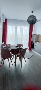 a dining room with a table and chairs in a kitchen at Apartament Alexandra Ressidence in Oradea +3 photos
