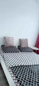 a bed with black and white sheets and pillows at Apartament Alexandra Ressidence in Oradea