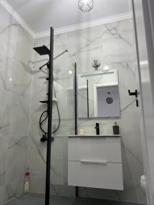 a white bathroom with a sink and a mirror at Apartament Alexandra Ressidence in Oradea