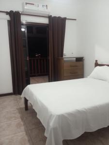 een slaapkamer met een wit bed en een raam bij Casa da Fê in São Sebastião