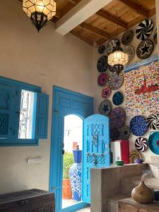 een keuken met blauwe deuren en borden aan de muur bij Taghazout Ocean View in Taghazout