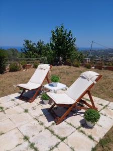 dwa leżaki i stół na patio w obiekcie Eftihia's Home w mieście Agia Triada