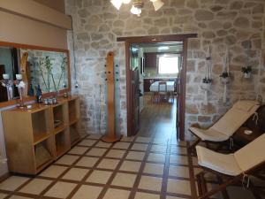 Eftihia's Home في Agia Triada: غرفة معيشة مع غرفة مع طاولة وكراسي