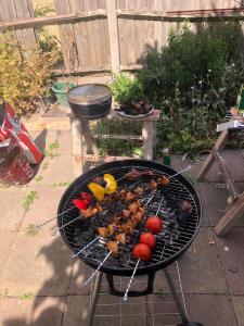a barbecue grill with meat and vegetables on it at Burney Tomar House in Croydon