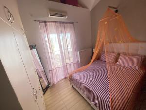 Schlafzimmer mit einem Bett mit Moskitonetz in der Unterkunft Rafaella's Maisonette at Rafaella Resort in Kokóni