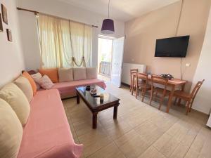 ein Wohnzimmer mit einem Sofa und einem Tisch in der Unterkunft Rafaella's Maisonette at Rafaella Resort in Kokóni