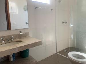 a bathroom with a sink and a toilet and a shower at Cristal casa de vidro in São Thomé das Letras +26 photos