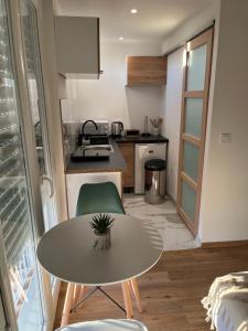 a small kitchen with a table and a small table and a table at Home Place Apartments - Gujan Arcachon in Gujan-Mestras