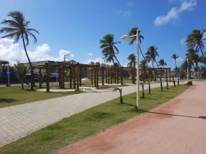 un parc avec des palmiers et une promenade dans l'établissement Apartamentos Stela Maris Praia e Aeroporto, à Salvador