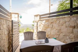 una mesa y sillas en un patio con una pared de piedra en Dioni Stone House, en Petrokefalo