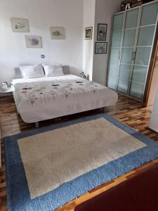 Schlafzimmer mit einem Bett mit blauem Teppich in der Unterkunft Garden apartment in Sečovlje