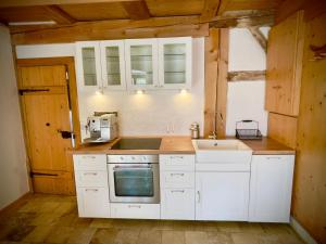uma cozinha com armários brancos e um lavatório em Rohrachhof em Treuchtlingen