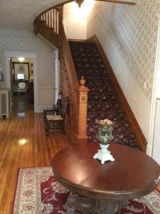 a room with a table and a stair case at Marmora and Lake Inn and Victorian Diner in Marmora