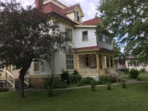 a large white house with a tree in the yard at Marmora and Lake Inn and Victorian Diner in Marmora