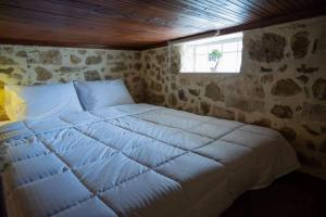 a large white bed in a room with a window at Dioni Stone House in Petrokefalo