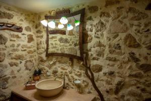 a bathroom with a sink and a mirror at Dioni Stone House in Petrokefalo +12 photos