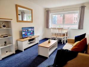 a living room with a couch and a tv and a table at One Bed Holiday Home in the Heart of Glasgow in Glasgow