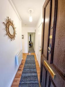 a hallway with a door and a rug on the floor at One Bed Holiday Home in the Heart of Glasgow in Glasgow