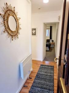 a hallway with a mirror on the wall and a rug at One Bed Holiday Home in the Heart of Glasgow in Glasgow
