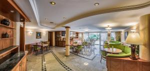 a restaurant with green chairs and tables in a room at Fortuna Villa in Hévíz