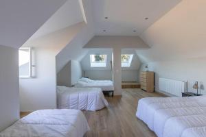 a attic bedroom with two beds and two windows at CABANA & La Villa sur la Colline - Au Calme 