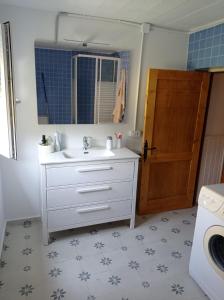 a bathroom with a sink and a washing machine at Amplia y cómoda casa de piedra con porche y jardín in San Roque de Ríomiera
