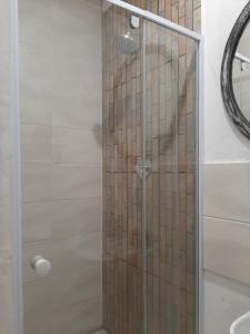 a shower with a glass door in a bathroom at The Cottage II in Grahamstown