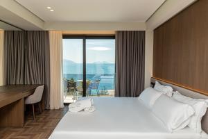 a hotel room with a bed and a desk with a view at Mazarine Hotel, Vlorë, Albania in Vlorë