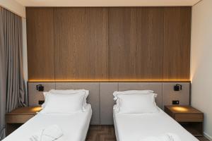 Een bed of bedden in een kamer bij Mazarine Hotel, Vlorë, Albania