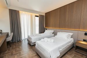 Een bed of bedden in een kamer bij Mazarine Hotel, Vlorë, Albania