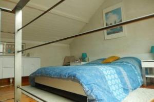 łóżko z niebieskim kocem w pokoju w obiekcie Maison Cocooning, bord de Sèvre Nantaise w mieście Nantes