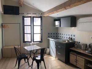 a kitchen with a table and chairs and a sink at ARLES: Studio de la place in Arles
