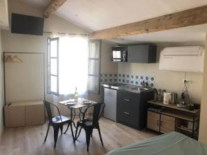 a kitchen with a table and chairs in a room at ARLES: Studio de la place in Arles +2 photos