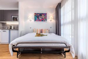 Un dormitorio con una cama grande y una cocina. en Disneyland Appartements familial avec piscine intérieur chauffé, parking gratuit A 5 minutes des parcs, en Serris 75 fotos más