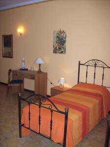 1 dormitorio con cama, mesa y escritorio en Il Giardino del Sole - Erice mare, en Erice
