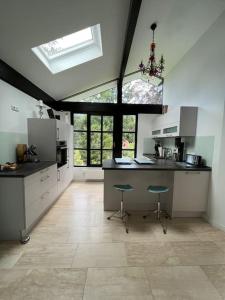 a large kitchen with a counter and stools in it at Gemütliches Haus zwischen Förde und Golfplatz in Heikendorf +9 photos