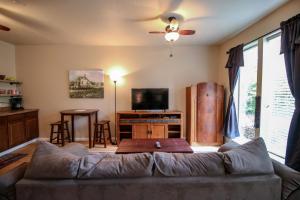 een woonkamer met een bank en een flatscreen-tv bij Creekside Cottage in Jacksonville