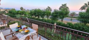 a table and chairs on a balcony with a view of the ocean at Rainbow Seafront Apartment in Praia a Mare