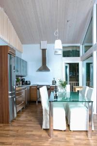 a kitchen with a glass table and white chairs at Patalaiska Villas in Ruokolahti