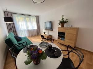 a living room with a table with flowers on it at OKO NA ZATOKĘ in Puck