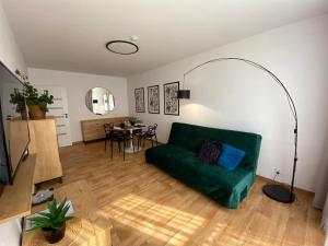a living room with a green couch and a table at OKO NA ZATOKĘ in Puck