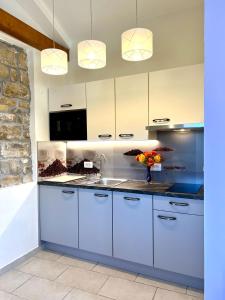 a kitchen with white cabinets and a sink at Casa Histria Apartments in Šmarje