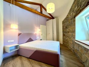a bedroom with a bed and a brick wall at Casa Histria Apartments in Šmarje